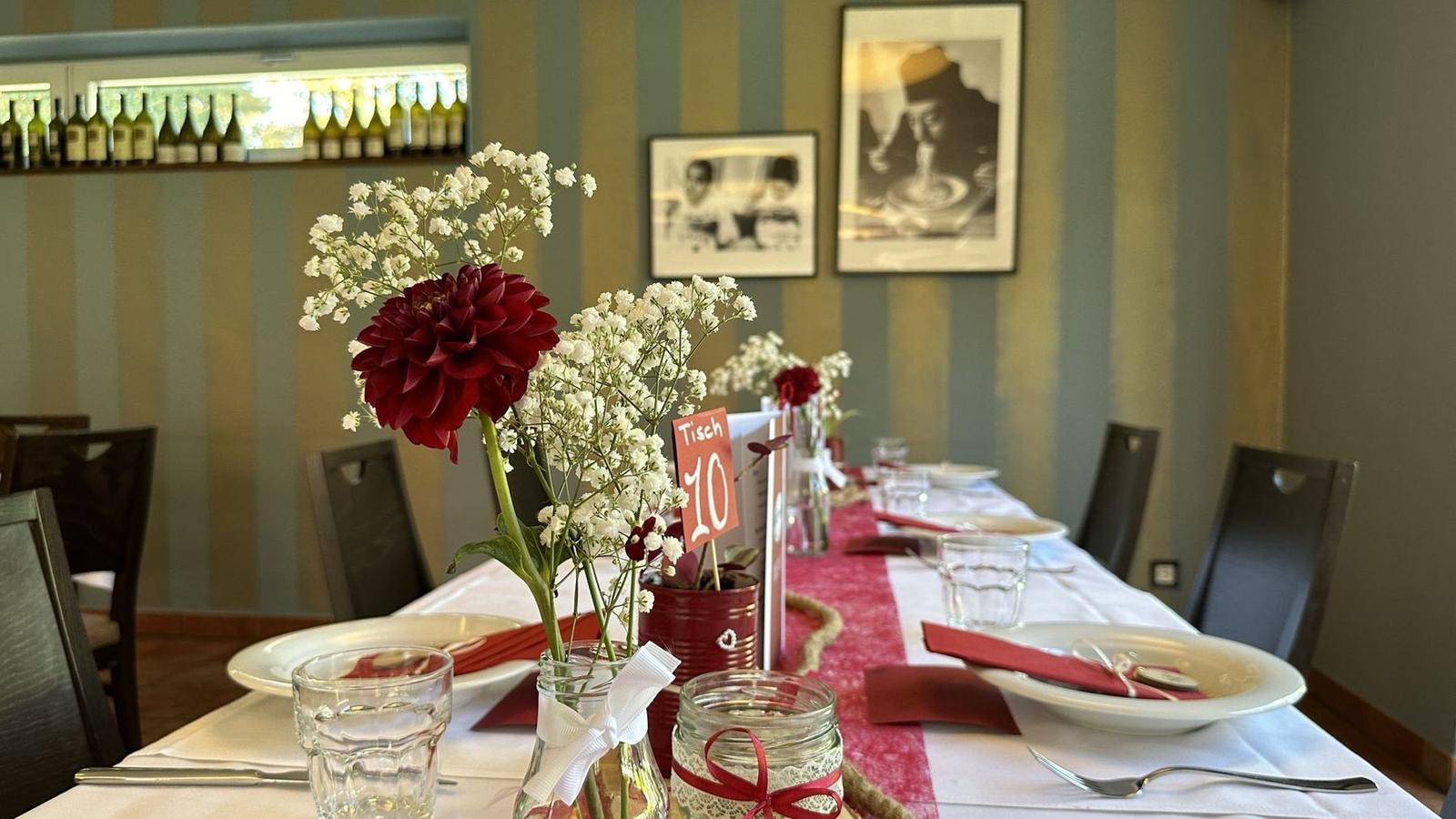 Tischnummer 10 zwischen roter Dahlie und Schleierkraut auf der gedeckten Tafel